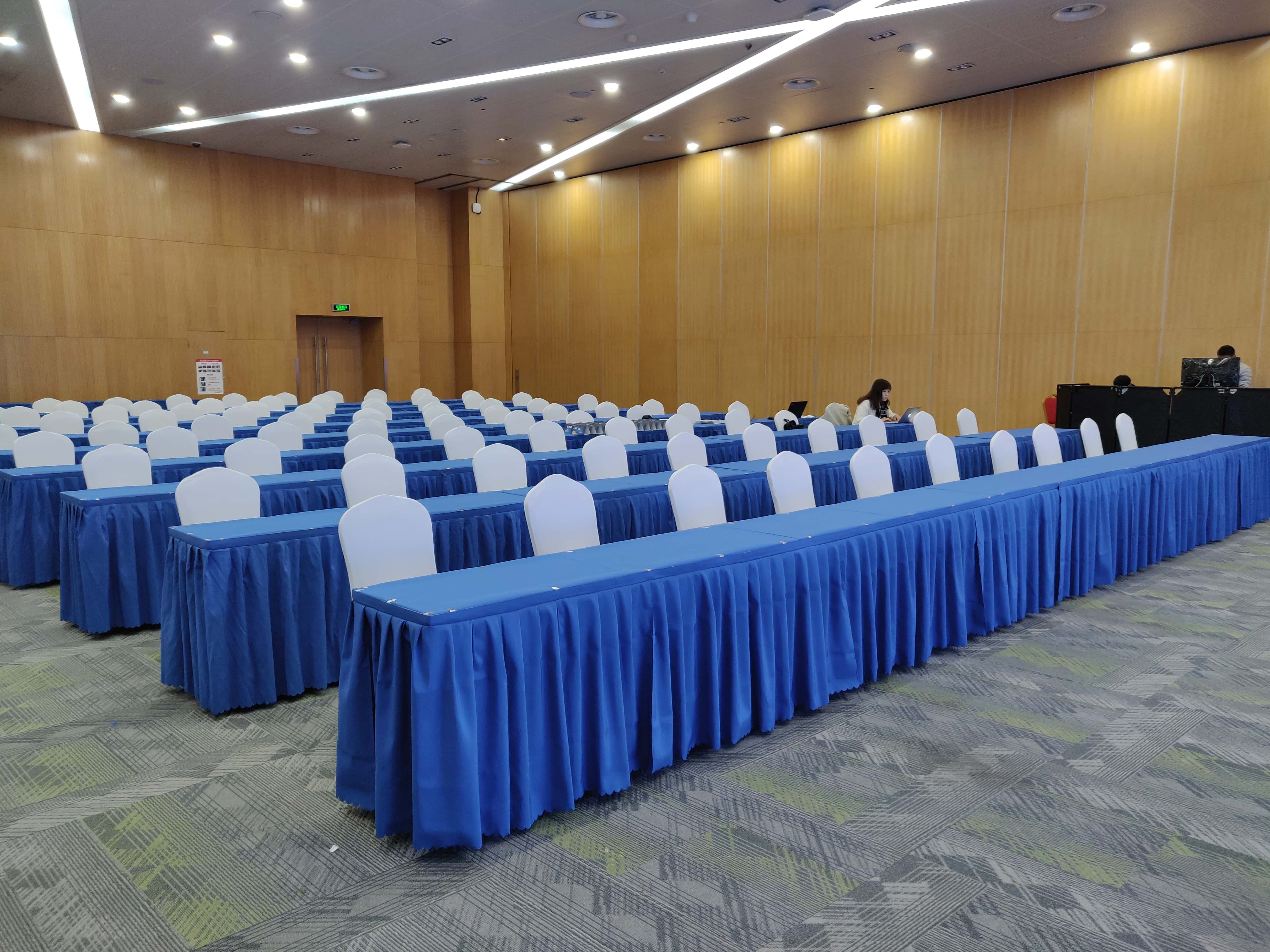 蓝色桌布长条桌配白色椅套椅子 同济大学培训会议厅 租多多会议桌出租 企业培训桌椅租赁 上海交通大学招聘会 培训桌椅租赁 上海高校活动家具 大型培训会场